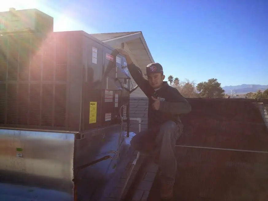 HVAC technician performing Air Duct Repair on a rooftop unit in Summit